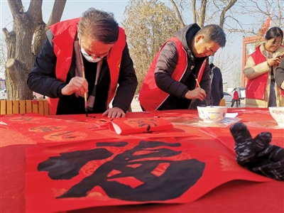 1月20日，在青銅峽市小壩鎮(zhèn)新林村村委會前的小廣場上，青銅峽市文化館工作人員為群眾免費書寫春聯(lián)。當(dāng)日，青銅峽市文化科技衛(wèi)生“三下鄉(xiāng)”暨“移風(fēng)易俗宣傳季”集中示范活動走進(jìn)該村。
    本報記者 李娜 張懷民 攝