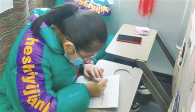     小學(xué)生楊斐在D4350次列車上寫作業(yè)。