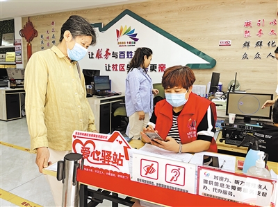 8月31日，社區(qū)工作人員幫助老年居民在手機(jī)上辦理業(yè)務(wù)。      本報(bào)記者 毛雪皎 攝