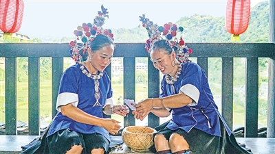     程陽(yáng)橋上，侗族婦女在展示制作侗族刺繡產(chǎn)品。繡品圖案精美、色彩艷麗，成為當(dāng)?shù)靥厣a(chǎn)業(yè)。